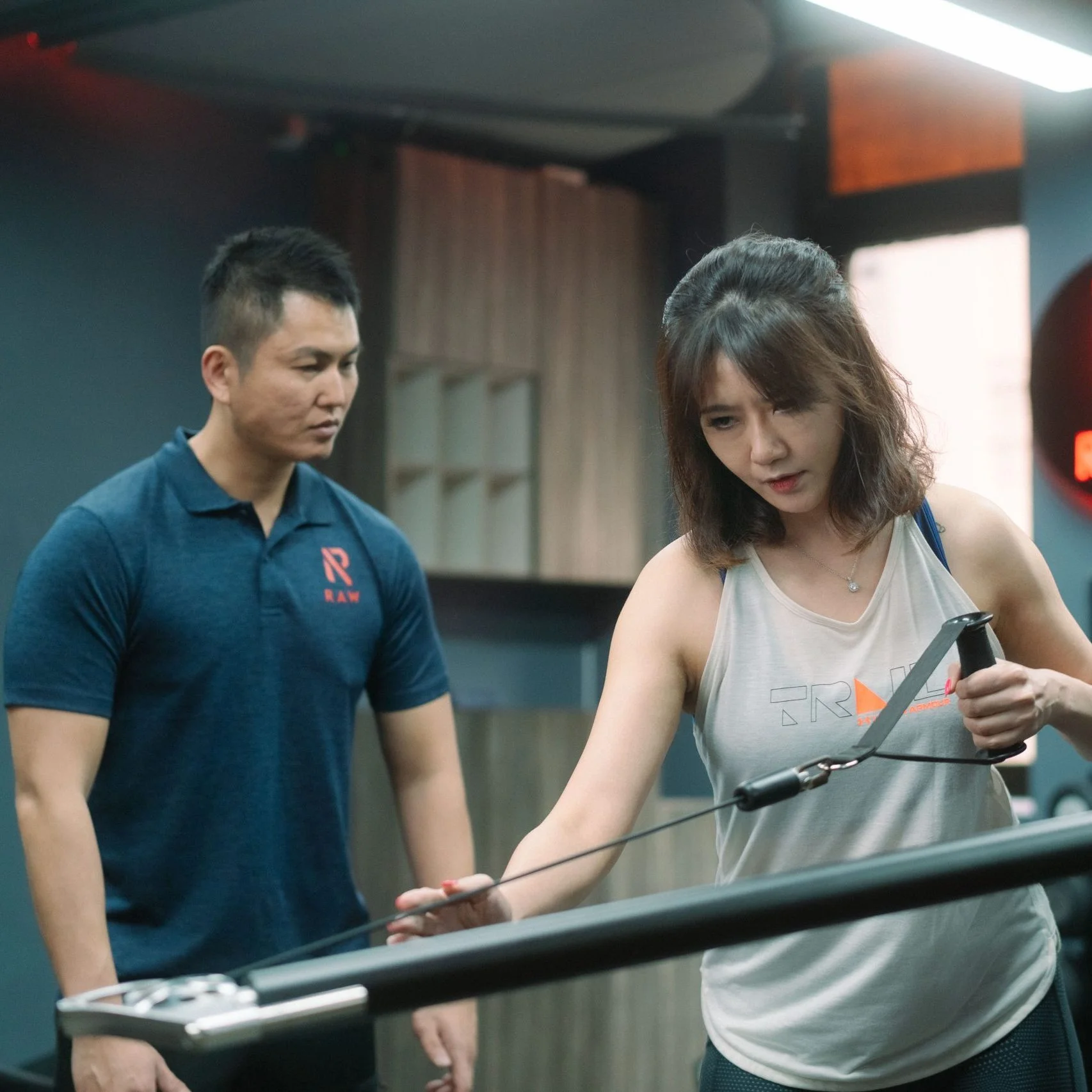 personal trainer training female client on functional strength training single arm row