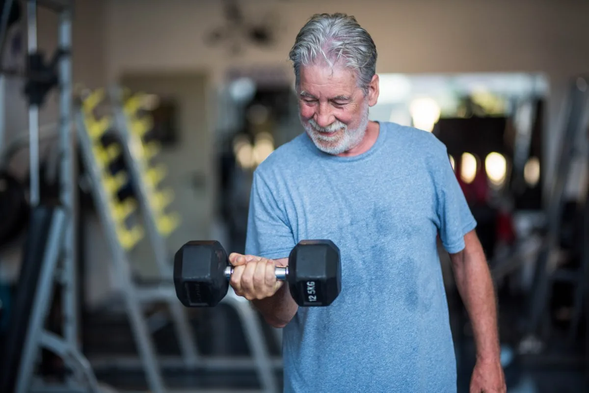 senior man lifting weights for ant aging